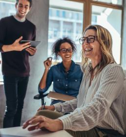 Happy business leader and her team laughing