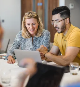 Man and a woman working together on one laptop