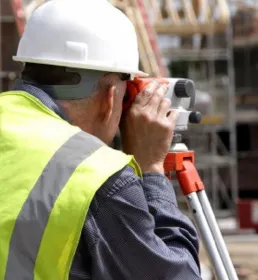 Surveyor using a theodolite