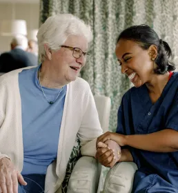 Older lady sitting with a nurse