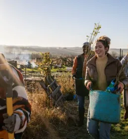People carrying gardening items on an allotment