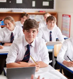 Young people in school uniform sat in class