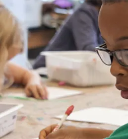 Early years classroom with children using pens and writing