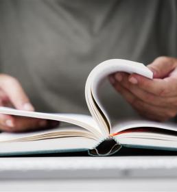 Someone holding a book and turning the pages