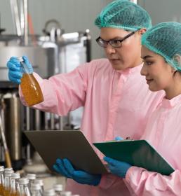 two scientists observing phial of liquid