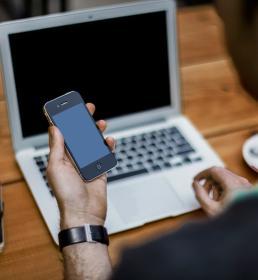 Man at laptop with phone