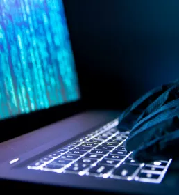 Hacker steals information using a laptop.