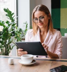 business woman sitting in a coffee shop on a tablet