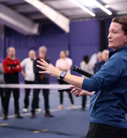 Tennis coach teaching class indoors