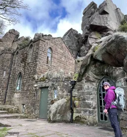 Woman in camping gear standing outside mountaineering hut