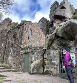 Woman in camping gear standing outside mountaineering hut