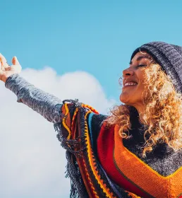 Smiling woman with her arm outstretched to the sky