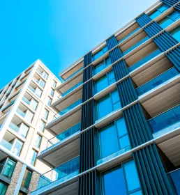 Looking up at an apartment block with blue sky