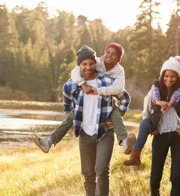 A young family hiking through a golden field