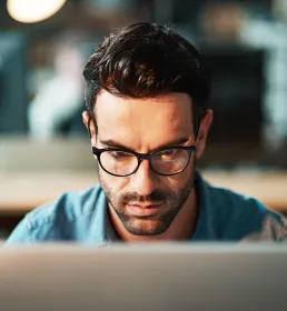 Young man using a computer at his desk in a modern office