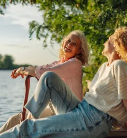 Two women sat lakeside