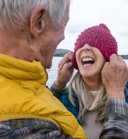 Older couple being silly pulling hat over face