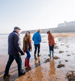 Family walking towards tide at the beach