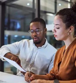 Man and woman discussing paperwork in office