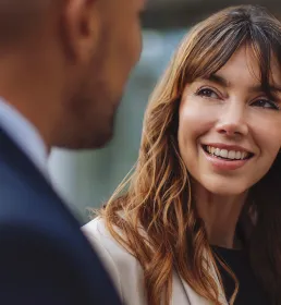 Female colleague listening to male and smiling