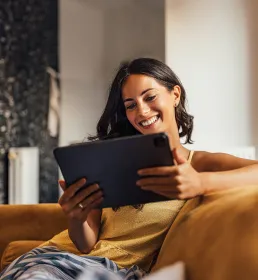 Woman reading tablet a home on sofa