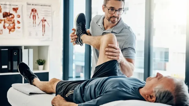 Physio flexing a patient's knee