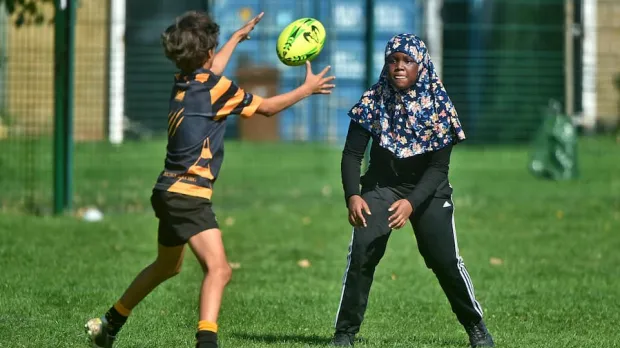 Girl in hijab playing rugby