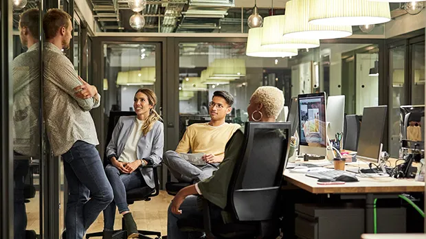 A group of people in an office chatting