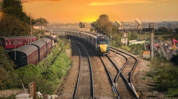 A train travelling on a railway at sunset