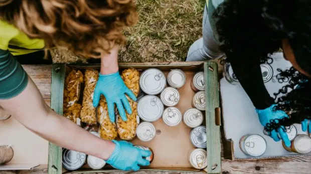Two people packing boxes with non-perishable goods