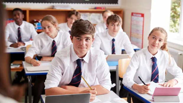 Young people in school uniform sat in class