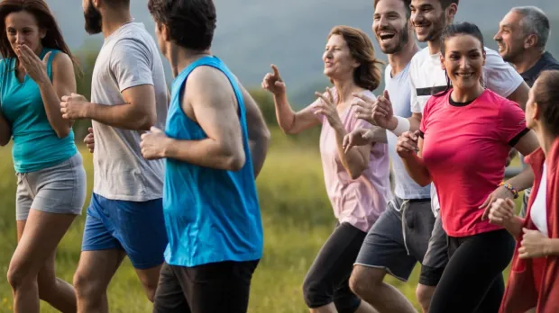 Health and wellbeing | group of runners Group of all ages and genders running in a park