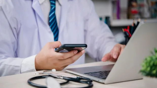 doctor looks at laptop