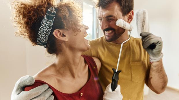 A couple playfully enjoying a moment while painting a room