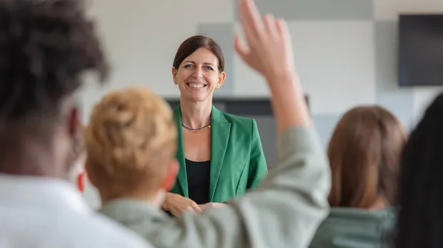 Benefits for Edinburgh Academy Teacher smiling in front of class of students