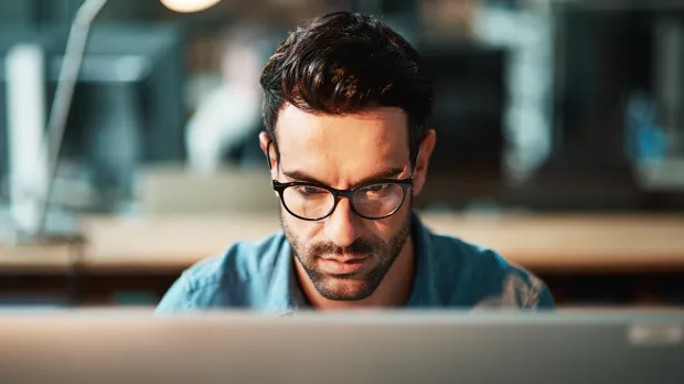 Young man using a computer at his desk in a modern office