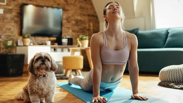 Health benefits: RSPCA Woman and dog doing home yoga