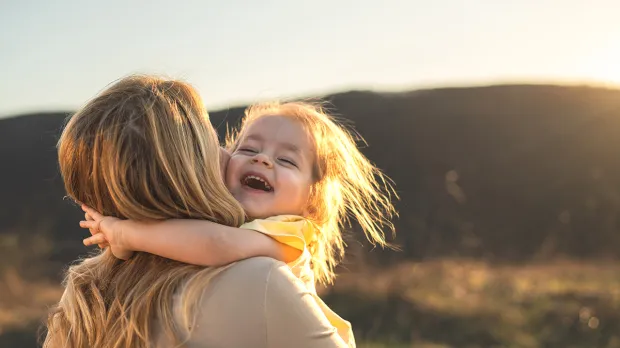 Lowell: Employee benefits Mom and daughter in sun glow enjoying cuddles