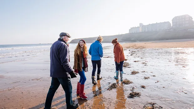 Family walking towards tide at the beach