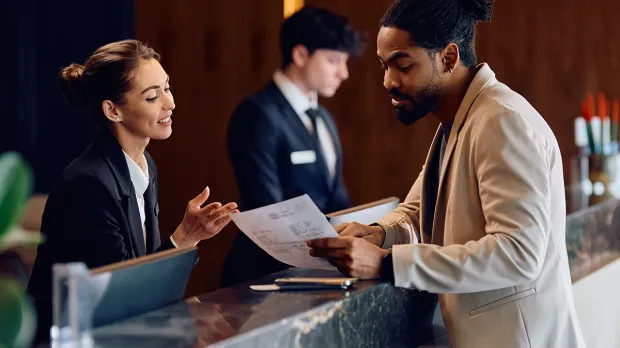 Man discussing paperwork at a hotel foyer