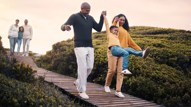 Multi-generational family walking down a coastal board walk