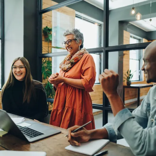 businesspeople smiling cheerfully during an office meeting