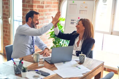 Male and female colleague sharing a high-five