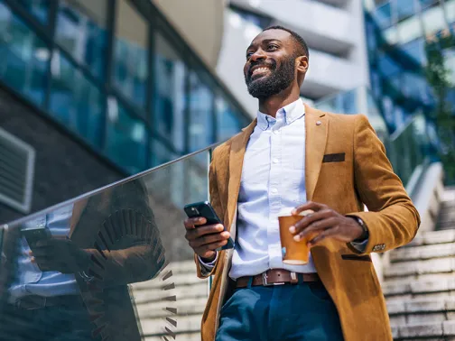 Man with mobile phone and coffee in his hands