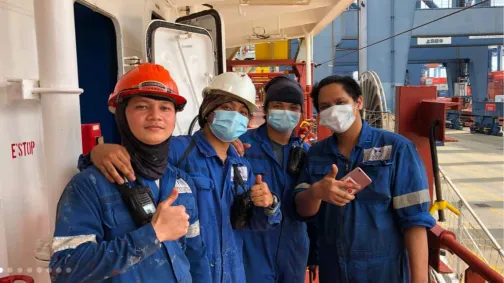 Four seafarers in work gear posing for a group shot