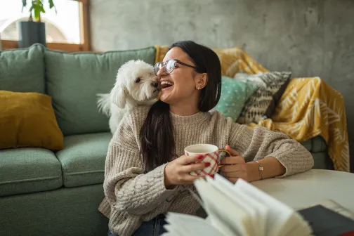 Woman and dog enjoying book and tea