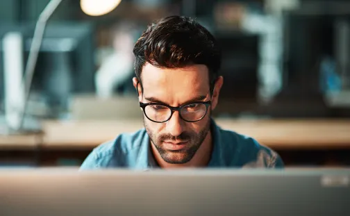 Young man using a computer at his desk in a modern office