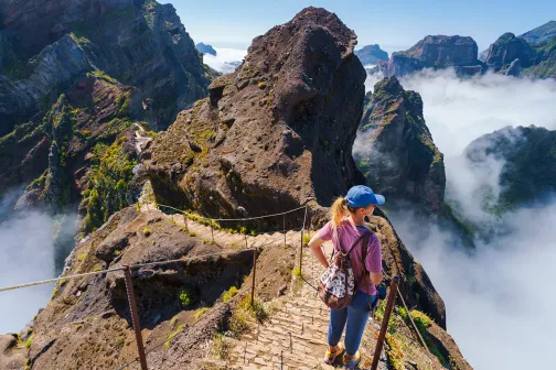 Woman on a rope bridge, up a mountain