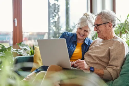 Retired couple together looking at a laptop