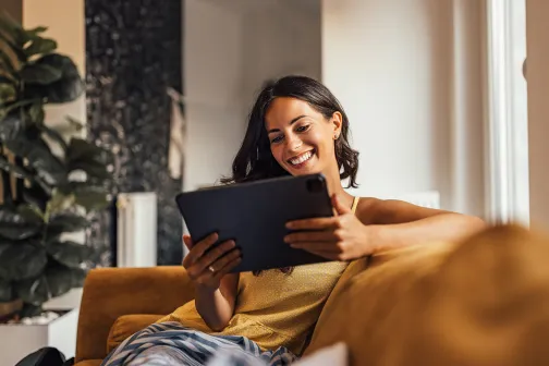 Woman reading tablet a home on sofa